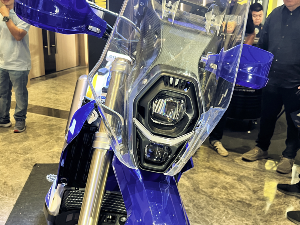 Front view of the ZXMOTO 450 Rally with a tall clear windscreen, stacked lights and blue handguards.