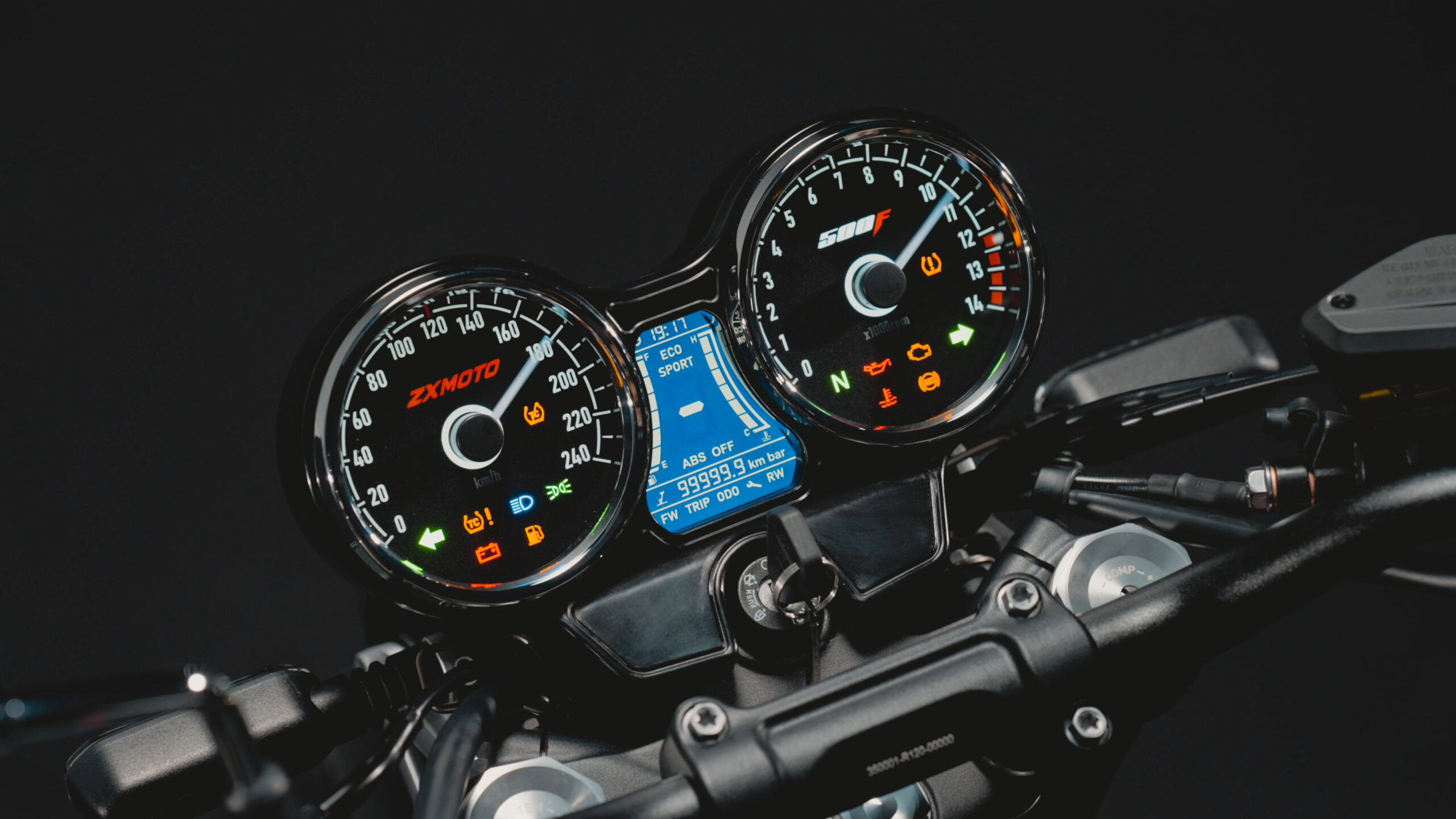 500F instrument cluster with two round dials, a central blue digital display and illuminated warning symbols.